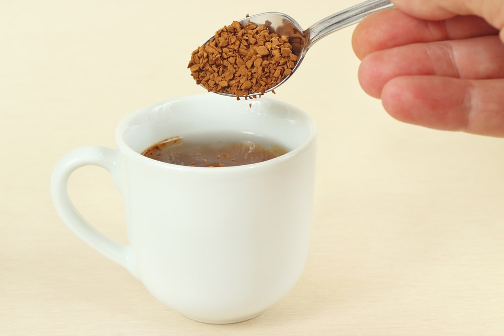 hand-pours-instant-coffee-spoon-cup