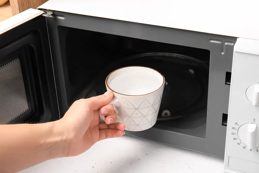 woman-cup-water-near-microwave-oven