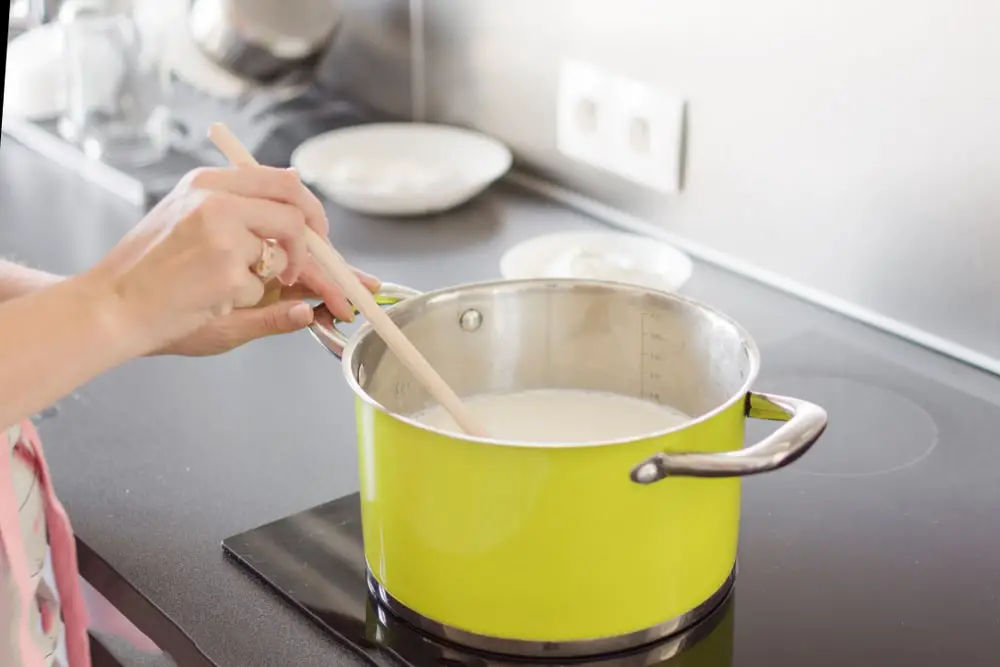 woman-preparing-bechamel-sauce-cream-pan