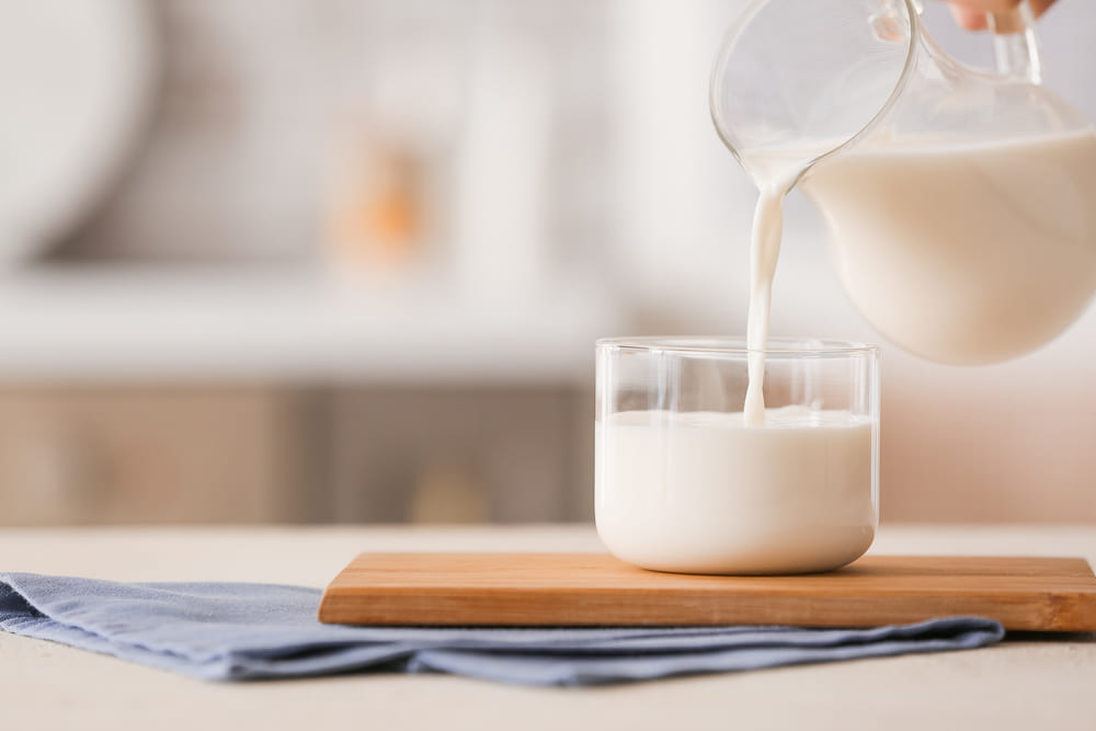 pouring-milk-into-glass-on-table