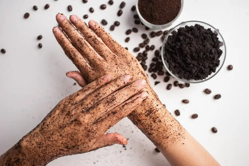 young-woman-hand-applying-coffee-grounds